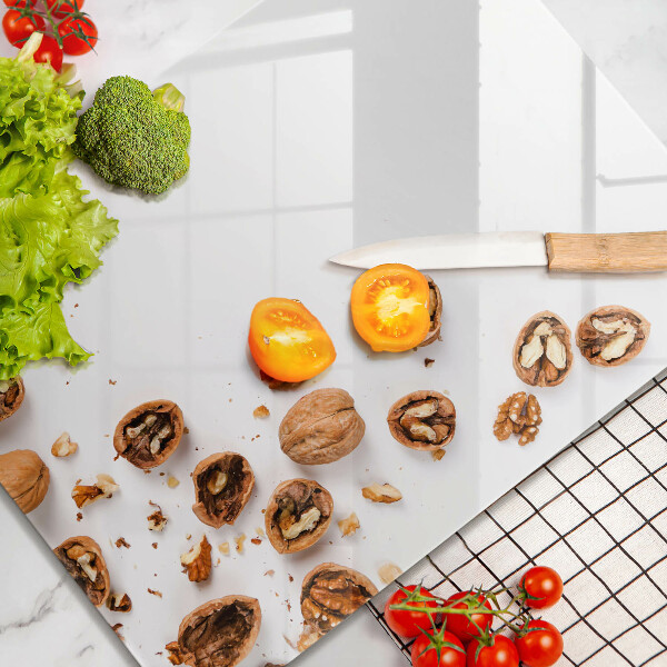 Tabla de cortar de vidrio Nueces sobre un fondo blanco